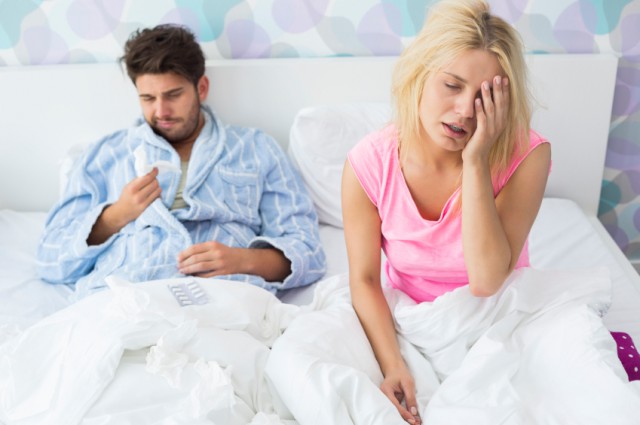 Irritated sick couple on bed at home