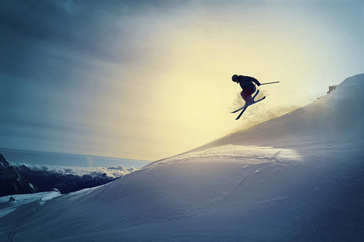 Off pist, back country skiing. Extreme skiing. Silhouette. Freestyle skier jumping in the air. Beautiful nature in a sunset time. Powder snow. Alps mountains snowy landscape. Cortina d’Ampezzo, Italy ski resort. Queen of the Dolomites.